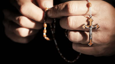 stock-footage-praying-hands-with-rosary-cross-closeup